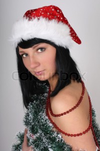 ‘Beautiful brunette woman in santa hat with christmas …