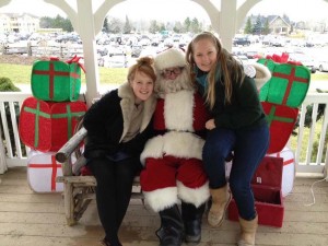 girls sit with santa on christmas