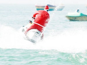 A man dressed in a Santa Claus suit fearlessly zips across the …